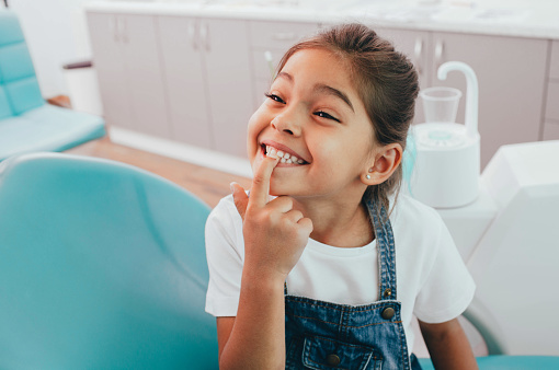 Little girl showing off dental sealant from Dental Care of Burlington in Burlington, MA