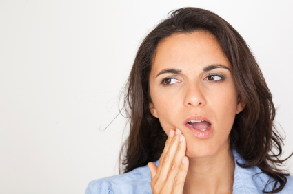 Woman holding mouth before appointment at Dental Care of Burlington in Burlington, MA