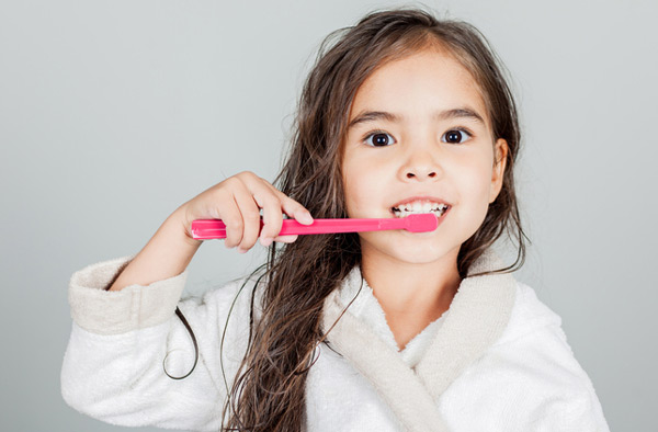 Young girl brushing her teeth at Burlington, MA office.