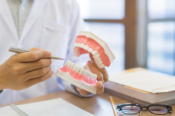 A dentist highlighting examples of gum disease on a diagram